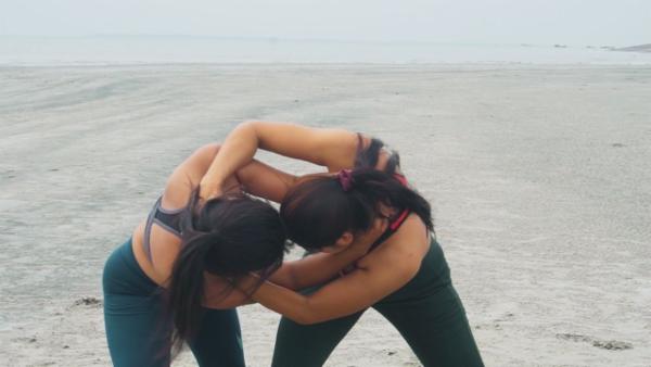 Two gorgeous Indian Women wrestle on the beach cover